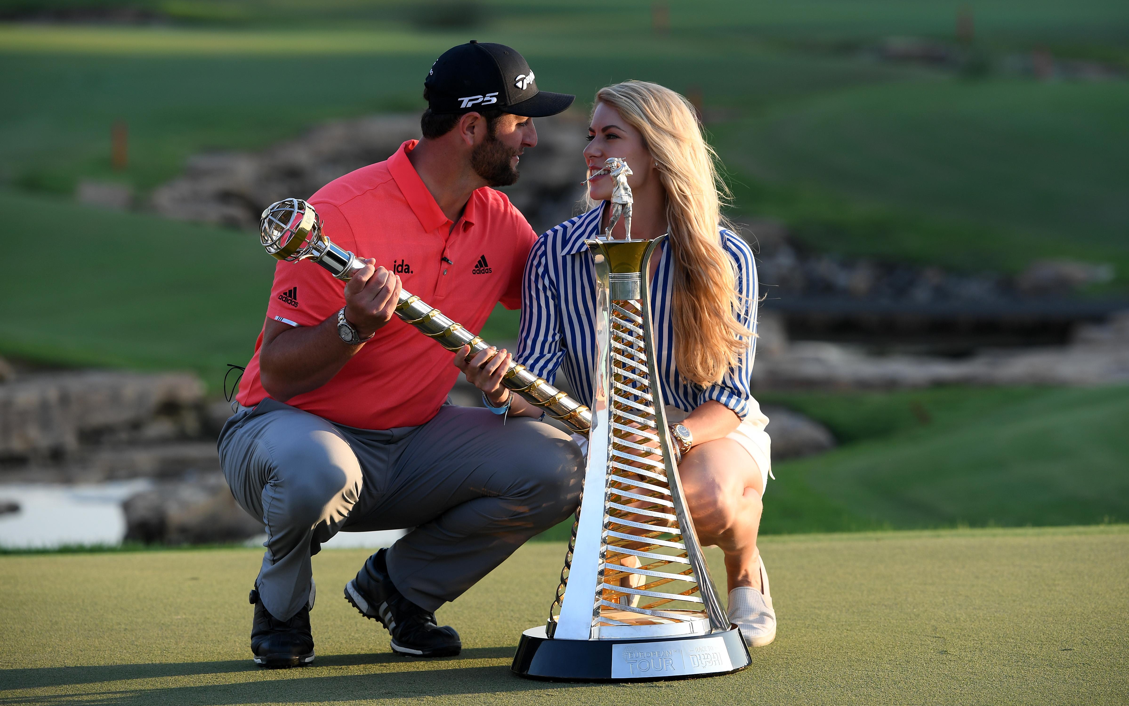 De Spaanse topgolfer Jon Rahm met vriendin Kelley Cahill na het winnen in Dubai